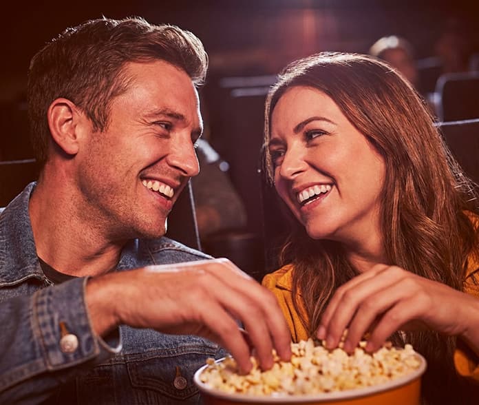 Couple sharing popcorn at a Downtown Burbank movie theater