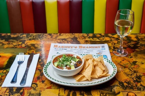 Barney's Beanery chips and dip with wine on a table with booth