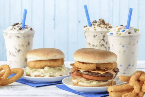 Fosters Freeze two burgers on blue plates, onion rings and three shakes