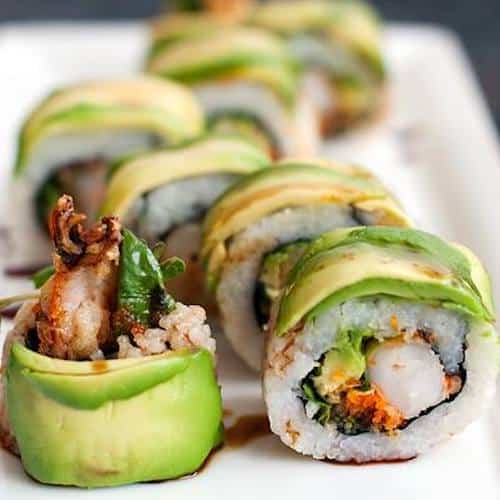 Sushi roll covered in avocado