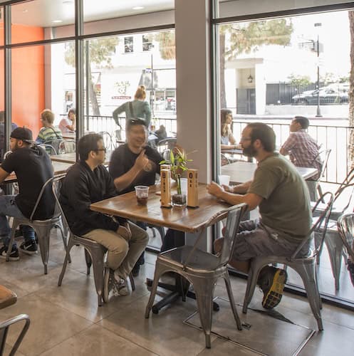 Carving Board dining room with a group sitting at a table in front of windows