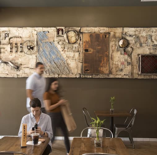 Inside Carving Board with textile artwork on olive green wall with woman at table