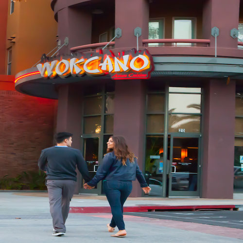 Wokcano sign with couple walking into the restaurant