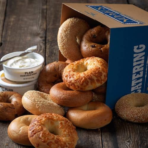 Noah Bagels in a box spilling out with cream cheese behind