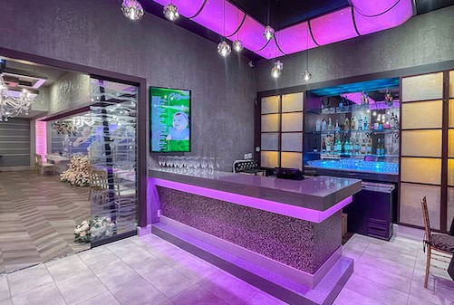 Olivia Restaurant event venue bar with purple lighting and display case