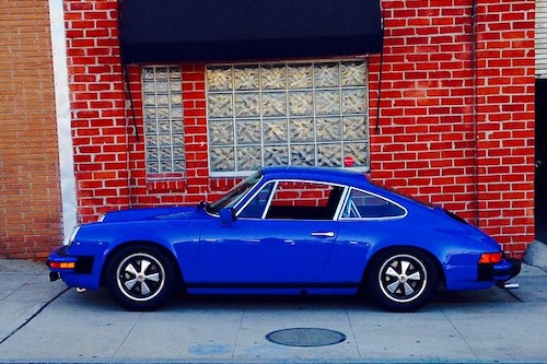 Porsche 912 in front of red brick building