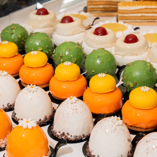 Beautiful pastries lined up in white, orange and green