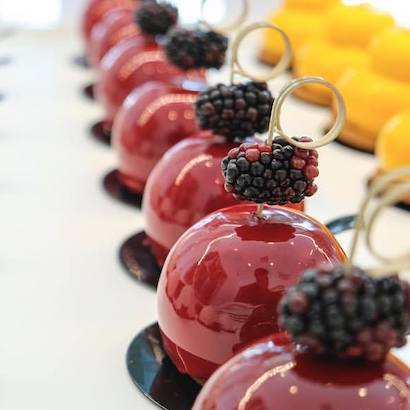 Rows of purple and yellow pastries