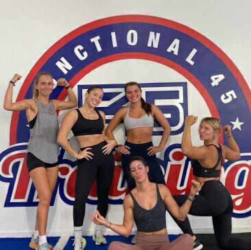 Athletes pose in front of the mural at F45 Training Gym