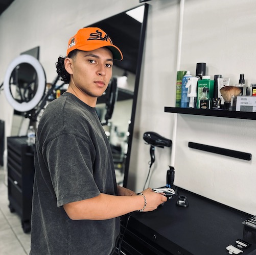 Purpose LA Barbershop worker stands with barber equipment