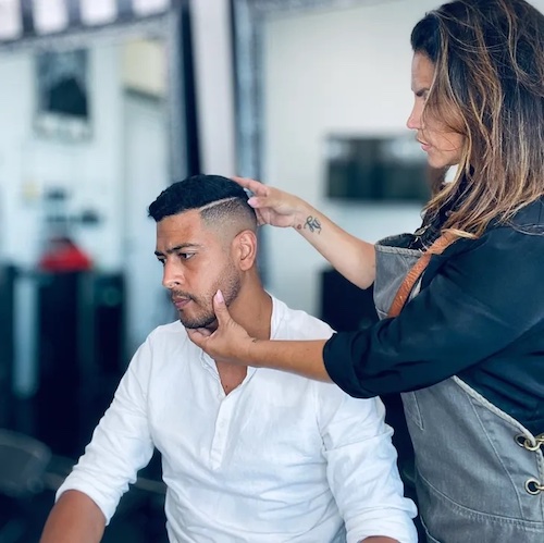 Purpose LA Barbershop stylist shows a hair cut to a man wearing white shirt