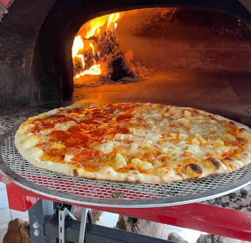 Pizza going into a brick oven