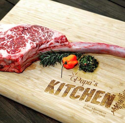 Papa's meat & seafood raw tomahawk on a cutting board