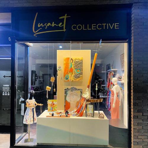 Lusanet Collective store window with black sign and yellow display