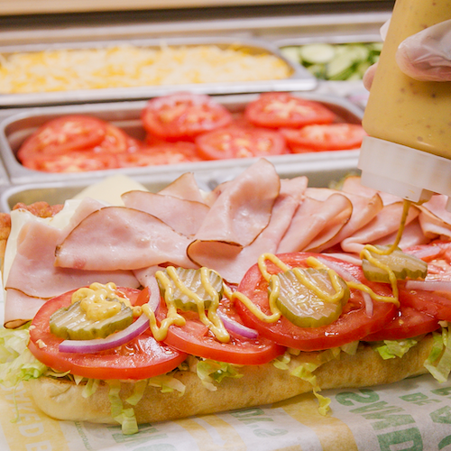 Subway sandwich laid flat with tomatoes