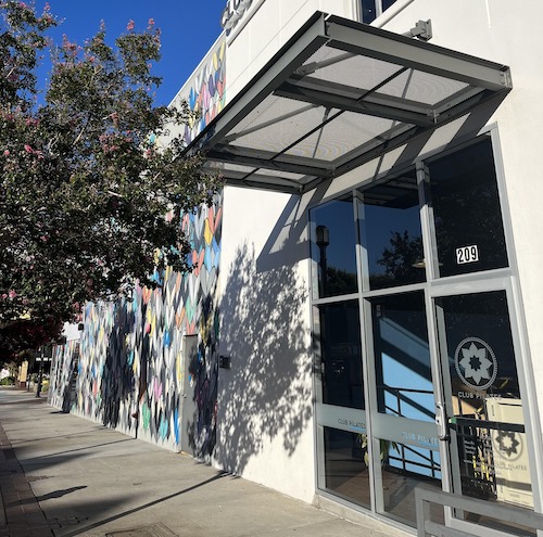 The entrance to Club Pilates with a glass door front