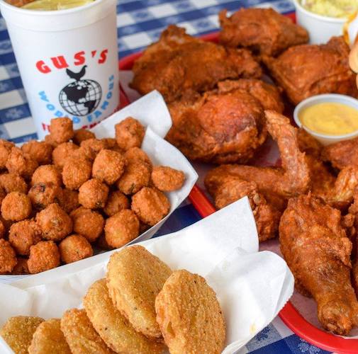 Gus Fried Chciken and tator tots with drink on a blue and white checkered tablecloth