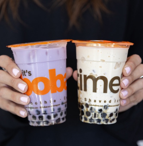 Two It's Boba Time drinks held up by hands