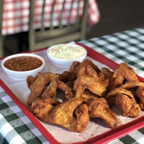 Gus Fried Chciken with two sides on a blue and white checkered tablecloth