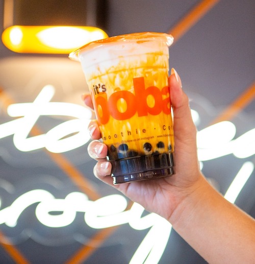 One It's Boba Time drinks held up by hands