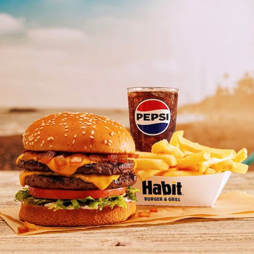 Habit Cheeseburger, french fires in carton and a soda drink with Pepsi logo