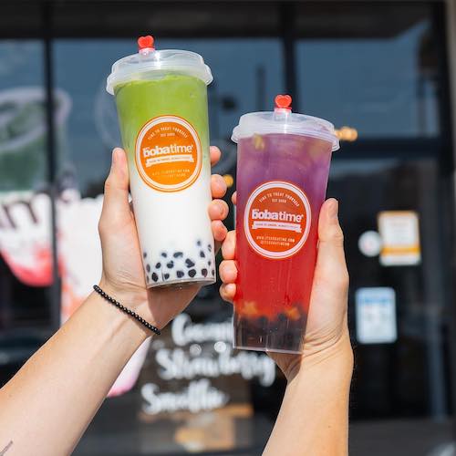 Two It's Boba Time drinks held up by hands