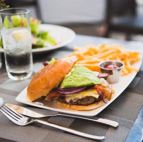 Cheeseburger with french fries on a rectangle plate and water