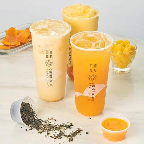 Sunright Tea Studio three cups of tea drinks with mango on grey background