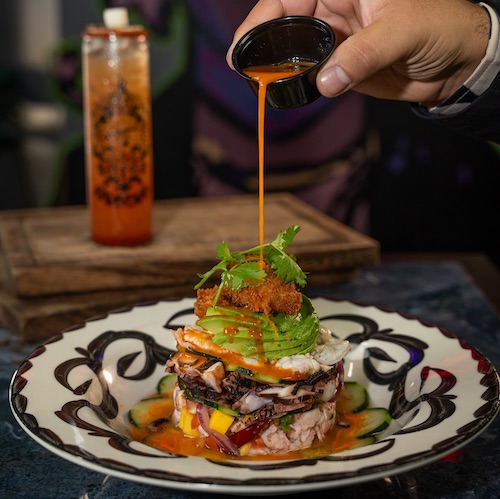 A mexican dish with sauce pouring on top