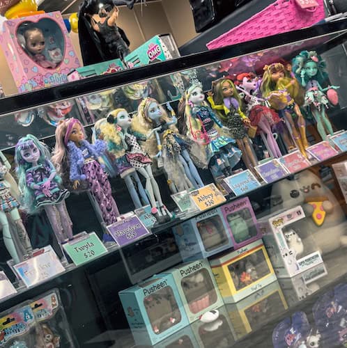 Rows of multicolored dolls lined up on a shelf