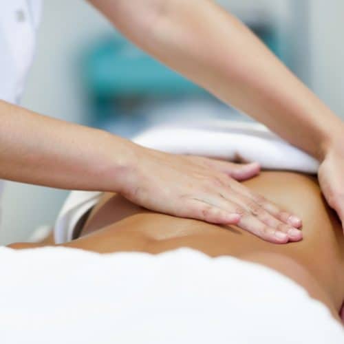 Woman receiving a massage wrapped in a white towel.